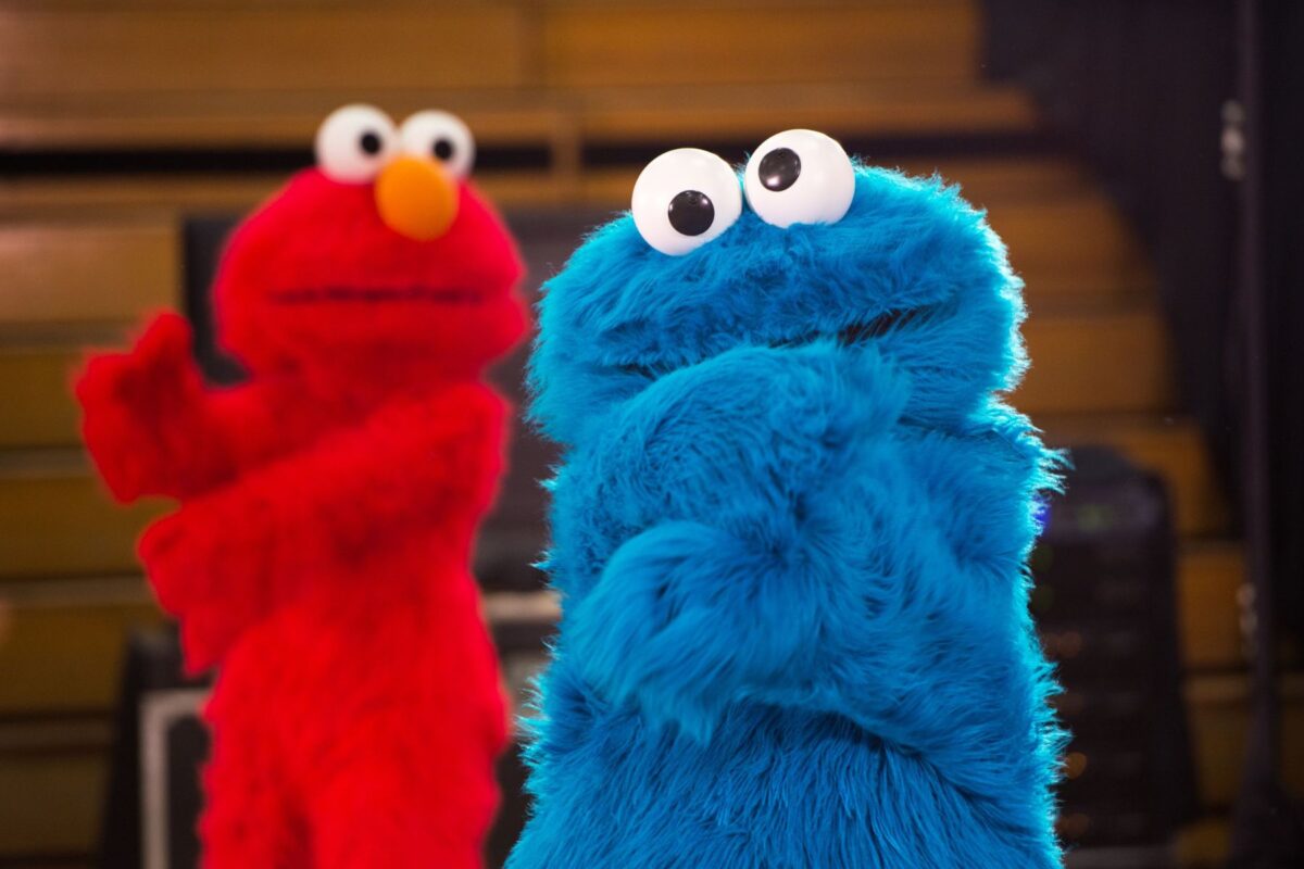 Sesame Street characters Cookie Monster and Elmo perform dance moves during the Sesame Street USO Experience for Military Families show. 2016. (U.S. Air Force photo by Louis Briscese/Released)